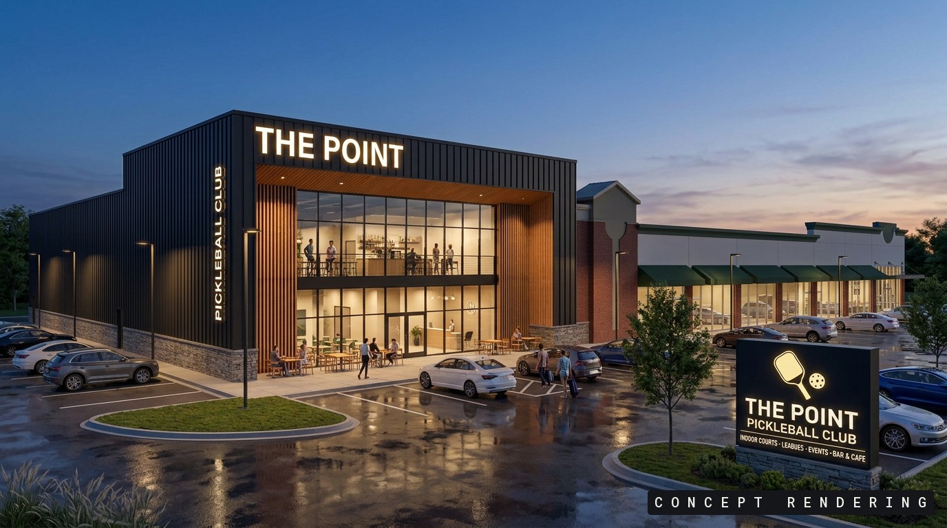 The Point at dusk — glazed two-story entry lit from within